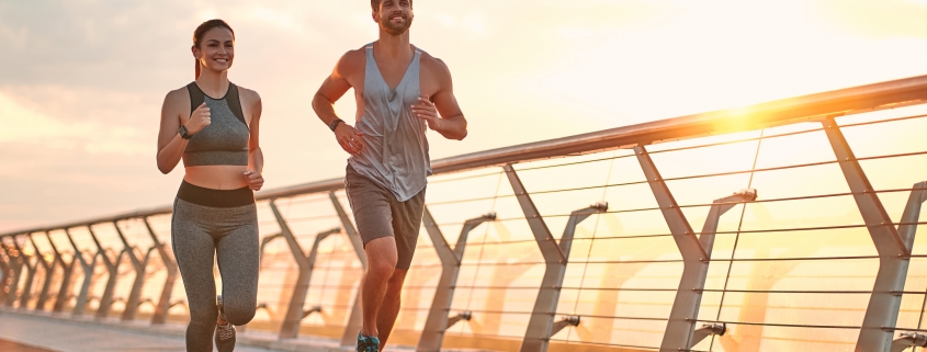 Two joggers running on a bridge, demonstrating health and fitness for a marathon.